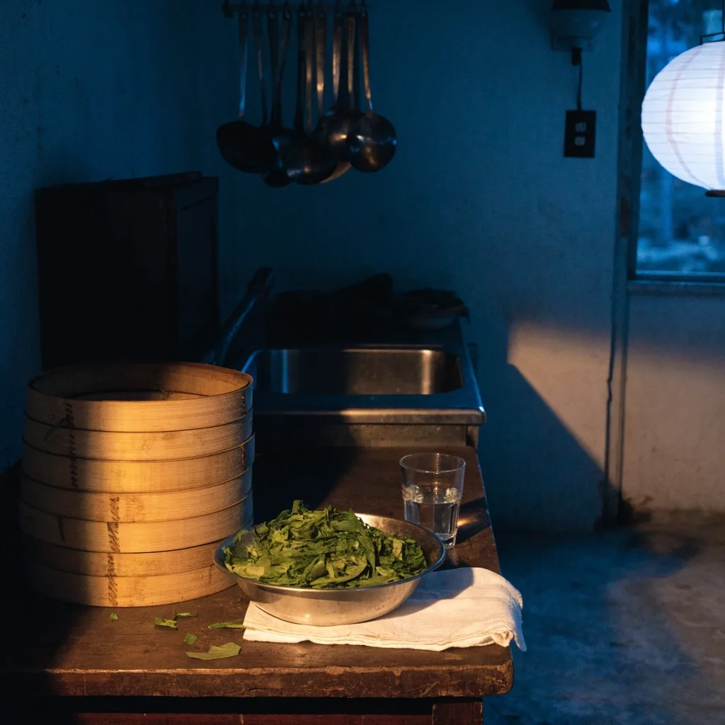Warung kitchen counter at dusk with a steamer and a bowl of greens